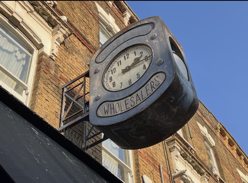 Broken “Wholesalers “ clock on Stoke Newington High Street N16 — stopped public clock